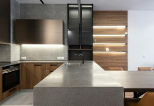 Vista diagonal de cocina moderna con iluminación LED y muebles de madera.