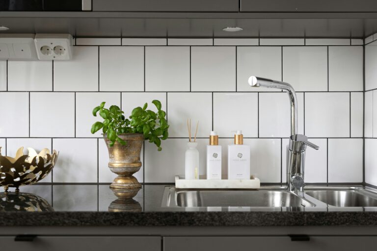 Cocina integral minimalista con gabinetes gris mate, backsplash blanco y encimera oscura